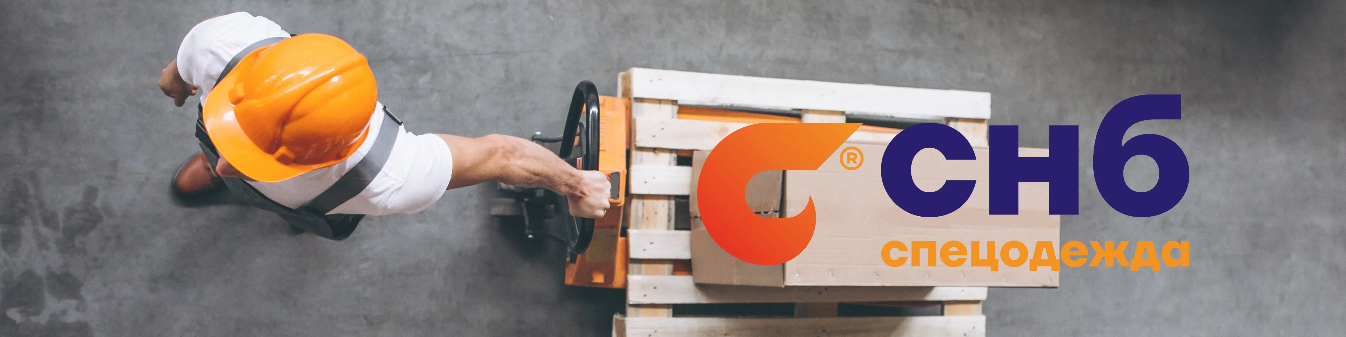 Работник в каске и спецодежде СНБ, перемещающий ящик на складе