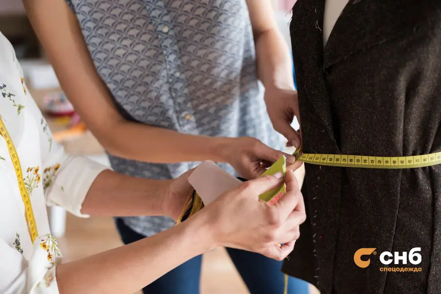 Специалист СНБ замеряет талию клиента для пошива спецодежды